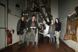 Investigators in slaughterhouse kill room - Investigators from Farm Transparency Project stand in front of the gas chamber in the BMK pig slaughterhouse, near Murray Bridge, South Australia. - Captured at BMK Food Slaughterhouse, Murray Bridge East SA Australia.