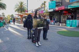 5 Question Challenge: Dominion Outreach Melbourne: 15 June 2025 - Animal rights activists participating in a street outreach event in St Kilda, Victoria, Australia. Some volunteers hold placards inviting pedestrians to answer 5 questions in exchange for a vegan treat. Others hold TVs showing footage from Farm Transparency Project's dairy investigations. Together, they bring awareness to the hidden reality of what happens to cows, calves, and bulls in the Australian dairy industry. - Captured at VIC.