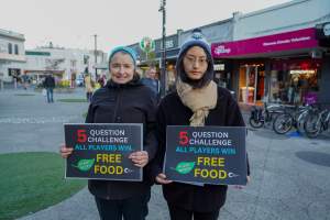 5 Question Challenge: Dominion Outreach Melbourne: 15 June 2025 - Animal rights activists participating in a street outreach event in St Kilda, Victoria, Australia. Some volunteers hold placards inviting pedestrians to answer 5 questions in exchange for a vegan treat. Others hold TVs showing footage from Farm Transparency Project's dairy investigations. Together, they bring awareness to the hidden reality of what happens to cows, calves, and bulls in the Australian dairy industry. - Captured at VIC.