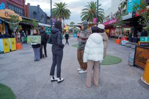 5 Question Challenge: Dominion Outreach Melbourne: 15 June 2025 - Animal rights activists participating in a street outreach event in St Kilda, Victoria, Australia. Some volunteers hold placards inviting pedestrians to answer 5 questions in exchange for a vegan treat. Others hold TVs showing footage from Farm Transparency Project's dairy investigations. Together, they bring awareness to the hidden reality of what happens to cows, calves, and bulls in the Australian dairy industry. - Captured at VIC.