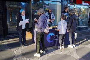 5 Question Challenge: Dominion Outreach Melbourne: 15 June 2025 - Animal rights activists participating in a street outreach event in St Kilda, Victoria, Australia. Some volunteers hold placards inviting pedestrians to answer 5 questions in exchange for a vegan treat. Others hold TVs showing footage from Farm Transparency Project's dairy investigations. Together, they bring awareness to the hidden reality of what happens to cows, calves, and bulls in the Australian dairy industry. - Captured at VIC.