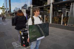 22 June 2025: 5 Question Challenge: Dominion Outreach Melbourne - Animal rights activists participating in a street outreach event in Southbank, Victoria, Australia. Some volunteers hold placards inviting pedestrians to answer 5 questions in exchange for a vegan treat. Others hold TVs showing footage from Farm Transparency Project's dairy investigations. Together, they bring awareness to the hidden reality of what happens to cows, calves, and bulls in the Australian dairy industry. - Captured at VIC.