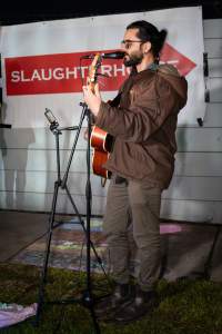 Cedar Meats Vigil - National Week Of Action 2025 - During the Shut Down Slaughterhouses Week of Action, we held a vigil outside of the Cedar Meats slaughterhouse in Brooklyn, Victoria.
During a two week investigation last year, our hidden cameras captured the handling and slaughter of animals, including newborn lambs and kids born in the holding pens of the slaughterhouse.
It was a Wednesday night when we gathered outside the slaughterhouse, holding signs and listening to music and speeches from investigators. We wanted to send a message to Cedar Meats, to let them know that we have not forgotten how they treat animals when they believe that no one is watching
We poured fake blood across their driveway as a visual reminder to everyone passing by, that animals arriving here are coming to their deaths. At the gates to the slaughterhouse, we each left a flower.
The images of animals whose deaths we have seen will haunt us forever, but we are determined to continue to fight in their name. - Captured at Cedar Meats, Brooklyn VIC Australia.