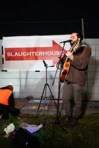Cedar Meats Vigil - National Week Of Action 2025 - During the Shut Down Slaughterhouses Week of Action, we held a vigil outside of the Cedar Meats slaughterhouse in Brooklyn, Victoria.
During a two week investigation last year, our hidden cameras captured the handling and slaughter of animals, including newborn lambs and kids born in the holding pens of the slaughterhouse.
It was a Wednesday night when we gathered outside the slaughterhouse, holding signs and listening to music and speeches from investigators. We wanted to send a message to Cedar Meats, to let them know that we have not forgotten how they treat animals when they believe that no one is watching
We poured fake blood across their driveway as a visual reminder to everyone passing by, that animals arriving here are coming to their deaths. At the gates to the slaughterhouse, we each left a flower.
The images of animals whose deaths we have seen will haunt us forever, but we are determined to continue to fight in their name. - Captured at Cedar Meats, Brooklyn VIC Australia.
